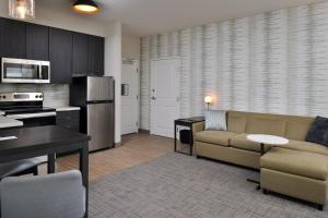 a living room with a couch and a kitchen at Residence Inn by Marriott St Louis Chesterfield in Chesterfield