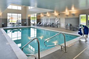 a swimming pool in a hotel with tables and chairs at Residence Inn by Marriott St Louis Chesterfield in Chesterfield