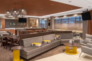 a hotel lobby with a couch and a bar at SpringHill Suites by Marriott Jackson in Jackson