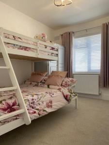 a bedroom with two bunk beds and a window at Beautiful Bungalow near to Beach in Selsey