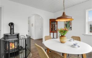 アリンエにあるCozy Home In Allinge With Wifiのテーブルと暖炉のあるダイニングルーム