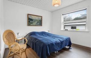 アリンエにあるCozy Home In Allinge With Wifiのベッドと椅子と窓のある寝室