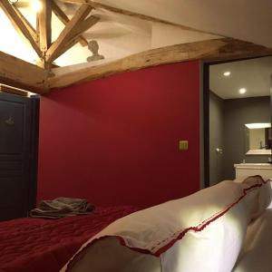 ein Schlafzimmer mit einem Bett mit einer roten Wand in der Unterkunft Boutique B&B- The Riverside Retreat in Jarnac