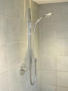 a shower with a shower head in a bathroom at Blar na Leisg self catering Lodge 1 in Drumbeg