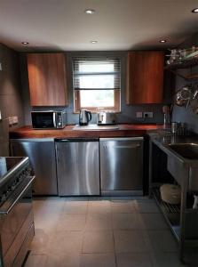 a kitchen with stainless steel appliances and a window at Blar na Leisg self catering Lodge 1 in Drumbeg