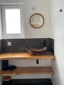 a bathroom with a sink on a wooden shelf at Gite au gré de la Loire piscine et spa in Saint-Mathurin