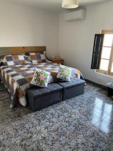 a bedroom with a bed and a couch with pillows at Casa Alora in Alora