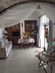Il Trullo di Nonno Angelo San Marco في لوكوروتوندو: غرفة معيشة مع طاولة وأريكة