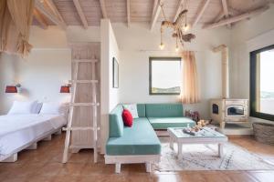 1 dormitorio con cama, sofá y mesa en Chamaloni Cottages, en Finikounta