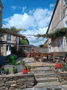 un patio con un banco de madera y una mesa en Pensión Albergue Matias Locanda, en Sarria