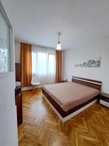 a bedroom with a large bed and a wooden floor at Lidda Apartment in residential area in Varna City