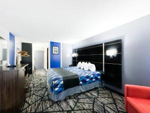 een hotelkamer met een bed en een rode bank bij Blaine Town Inn & Suites in Blaine