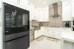 a kitchen with white cabinets and a black refrigerator at The tropical paradise villa in Miami