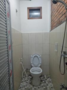 Baño pequeño con aseo y ventana en Paviliun Omah Ndanu, en Yogyakarta