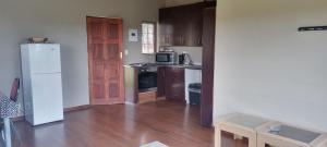 a kitchen with a white refrigerator and a wooden floor at ThakhuBrunfelsia in Secunda