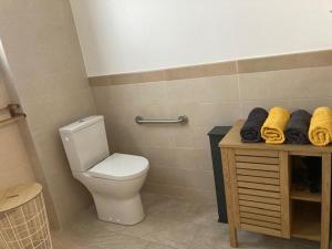 a bathroom with a toilet and a table with towels at La bulle dans le sable in Étang-Salé