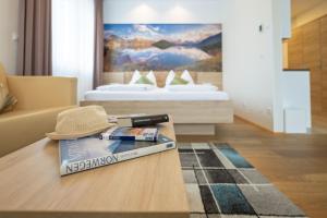 Cette chambre comprend un lit et une table avec un chapeau. dans l'établissement PM-PremiumAPART Strassgang, à Graz