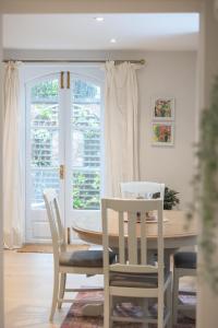 una sala da pranzo con tavolo, sedie e finestra di Spacious 2BR Victorian Cheltenham flat in Cotswolds Sleeps 6 - FREE Parking a Cheltenham