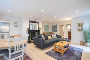 een woonkamer met een bank en een tafel bij Spacious 2BR Victorian Cheltenham flat in Cotswolds Sleeps 6 - FREE Parking in Cheltenham