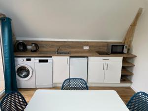 a kitchen with a sink and a table and chairs at Gite au gré de la Loire piscine et spa in Saint-Mathurin