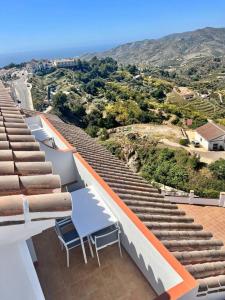 un groupe de chaises assises au sommet d'un stade dans l'établissement Ático con increíbles vistas a las montañas y mar, à Frigiliana