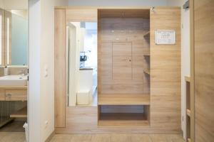 a bathroom with a closet with wooden walls at PM-PremiumAPART Strassgang in Graz