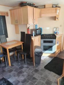 a small kitchen with a table and a stove at R and B static Caravan in Skegness