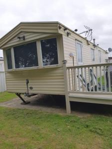 a mobile home with a porch and a deck at R and B static Caravan in Skegness