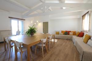 sala de estar con mesa de madera y sofá en Bastide Magnolia - Les dépendances, Roussillon, en Roussillon