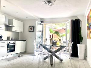 a kitchen with a glass table and white cabinets at Les Lodges de Saint Cassien in Montauroux