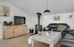 FjerritslevにあるNice Home In Fjerritslev With 3 Bedroomsのリビングルーム(ソファ、テーブル、テレビ付)