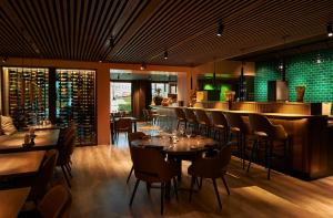 ヴァイレにあるHotel Hedegaardenのテーブルと椅子のあるレストラン、バー