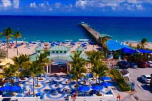 een luchtzicht op een strand met palmbomen en de oceaan bij Palm Paradise-Seaside Home w Heated Saltwater Pool in Fort Lauderdale