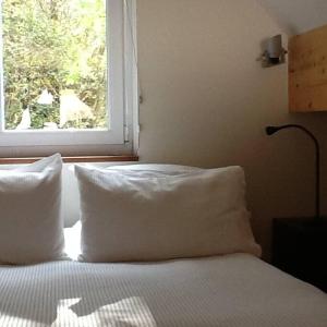 a bed with two pillows and a window in a bedroom at Blar na Leisg, Self catering Lodge 2. in Drumbeg