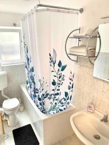 een badkamer met een douchegordijn, een toilet en een wastafel bij Citynahe 2-Zimmer Wohnung in Lübeck
