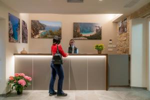 a woman is standing at a counter in a room at Goloritzè Room and Breakfast in Baunei