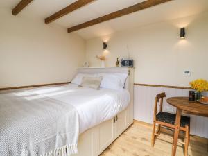 a bedroom with a bed and a wooden table at Buzzards in Crediton