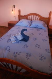 a bed with a blanket with a letter c on it at Maison familliale Saint Pierre in Sainte-Luce +3 photos