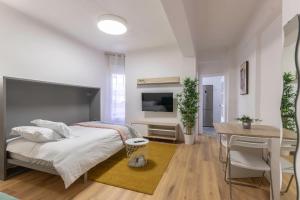 une chambre avec un lit, un bureau et une télévision dans l'établissement 2 paradas al CascoViejo, 1 min al metro - Basarrate, à Bilbao