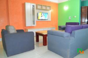 a waiting room with two chairs and a table and a tv at RESIDENCES MICKEL in Yaoundé