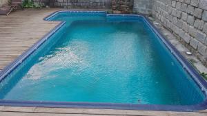 a swimming pool with blue water on a deck at Trip Adventure Hostel in Porto Belo