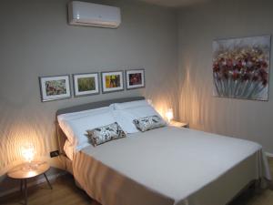 ein Schlafzimmer mit einem weißen Bett mit zwei Kissen darauf in der Unterkunft Alla Torre - nel cuore del Borgo storico in Castagnole Lanze