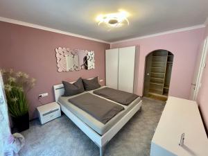 ein Schlafzimmer mit einem Bett und einer rosa Wand in der Unterkunft Ferienwohnung Unterlerchner in Afritz