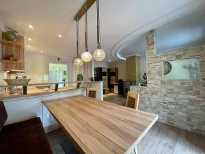 a kitchen with a wooden table and a stone wall at Ferienwohnung Unterlerchner in Afritz