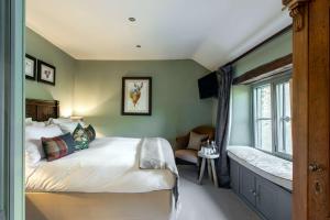 Un dormitorio con una cama grande y una ventana en The Wheatsheaf Inn en Bourton on the Water