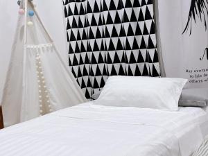 a white bed with a black and white headboard at 1949 Dreamy Home in Panglao