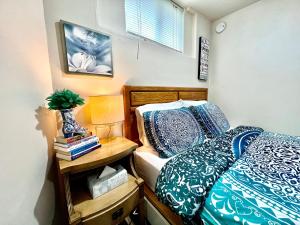 um quarto com uma cama e uma mesa de cabeceira com um candeeiro em Private Room with Shared Bathroom on a Lower Level of a Big and Peaceful House em Seattle