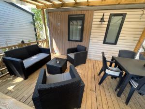 a patio with furniture and a table and chairs at Mobil home Petit Paradis, 6 personnes, Bord de mer, Camping Del Mar Village in Argelès-sur-Mer