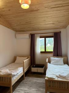 two beds in a room with wooden ceilings at Villa Nar in Cıralı