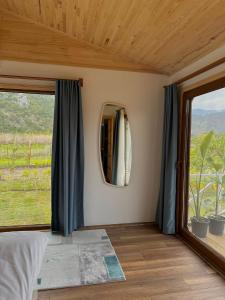 a bedroom with a large window and a mirror at Villa Nar in Cıralı